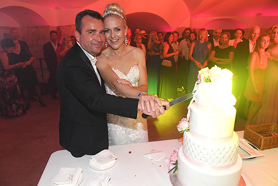 Falk Raudies mit Frau Andrea schneiden die Hochzeitstorte an ((©Foto: Schneider-Press/W.Breiteneicher)